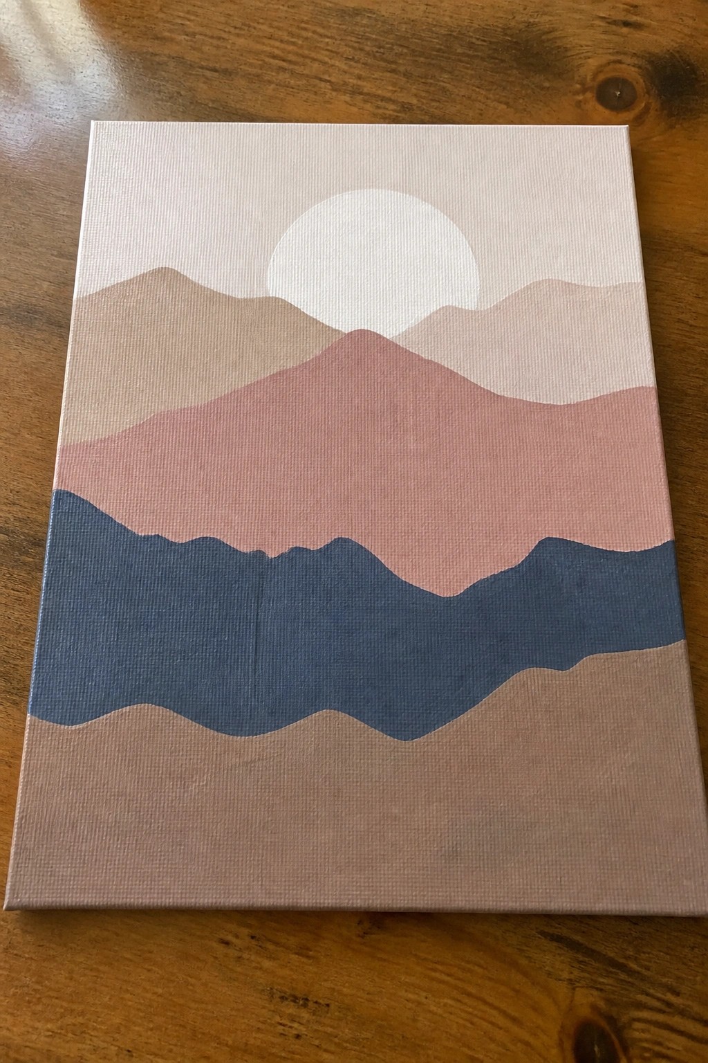 Abstract mountain landscape painting in soft pink, blue, and beige tones with a white sun
