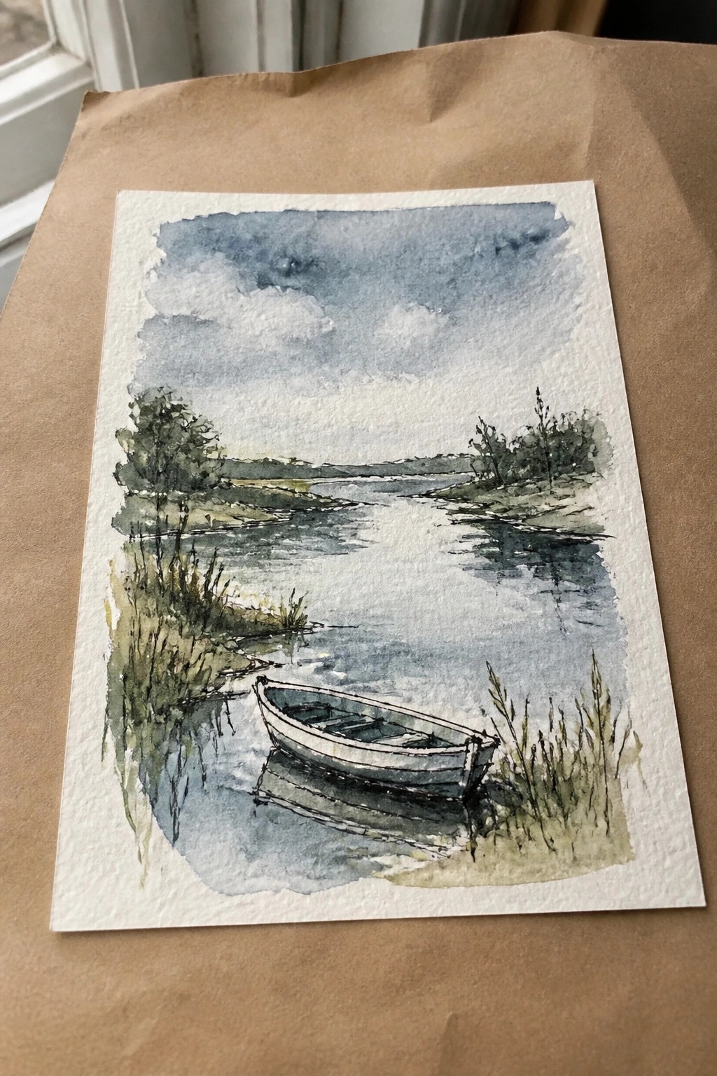Watercolor of a small rowboat on calm water by grassy banks under cloudy sky.