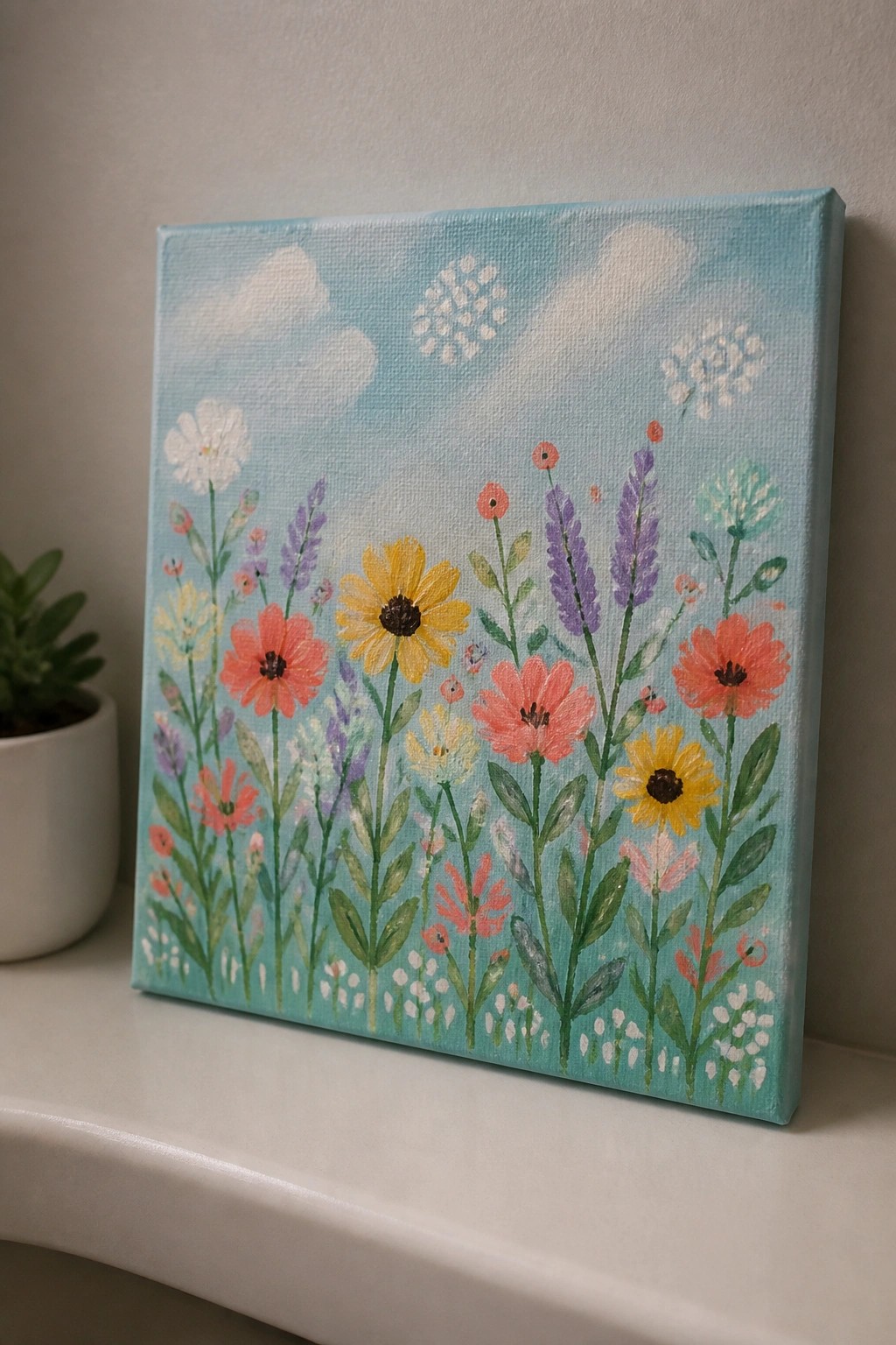 Colorful wildflower painting on canvas with blue sky, pink and yellow blooms