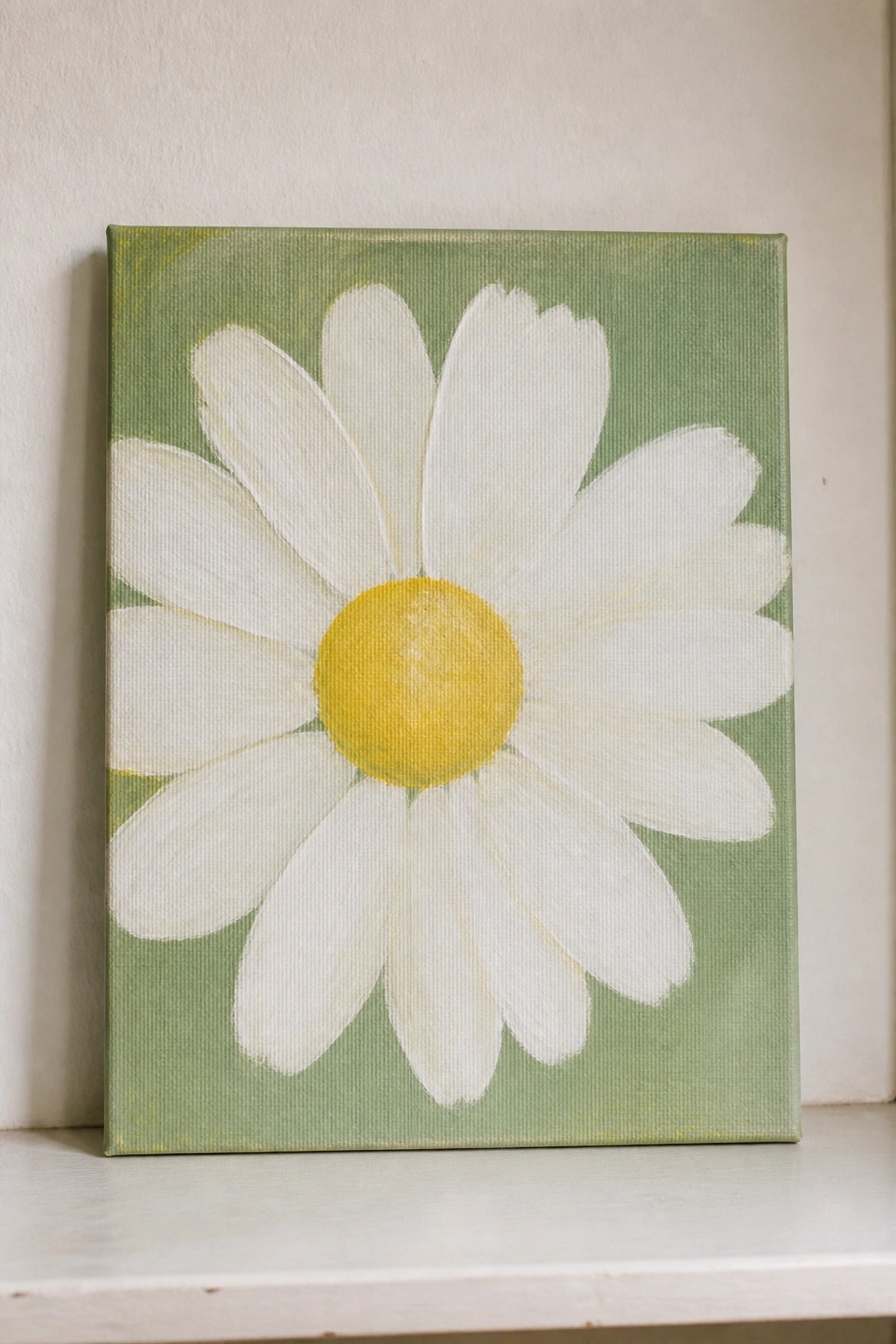 Painting of white daisy with yellow center on green canvas background