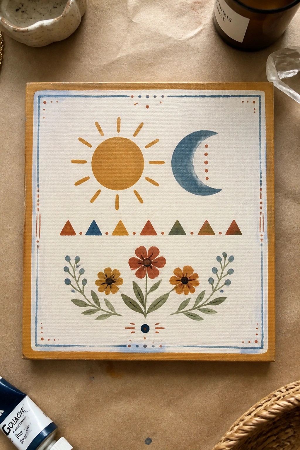 Folk-style canvas painting of sun, moon, triangles, and flowers with dotted borders