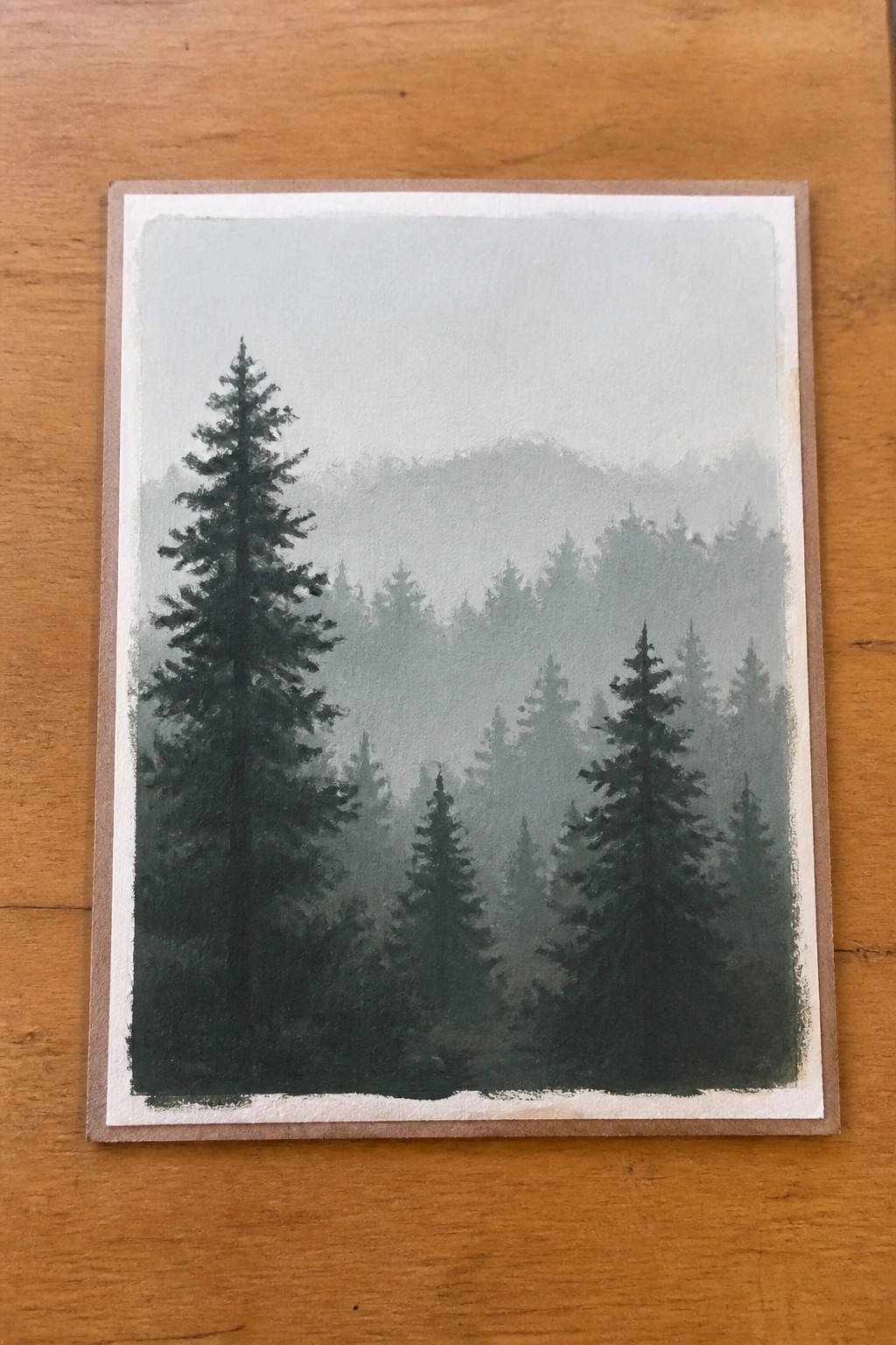 Misty forest painting with tall dark green pine trees and foggy hills
