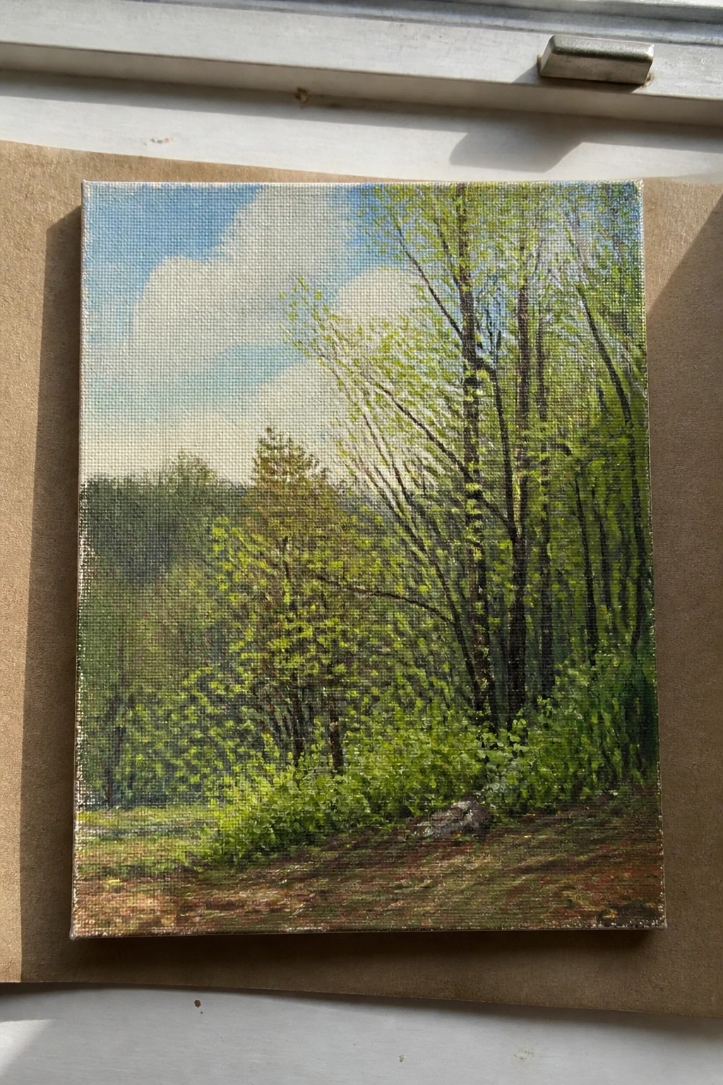 Canvas painting of lush green forest with tall trees, dirt path, and blue sky
