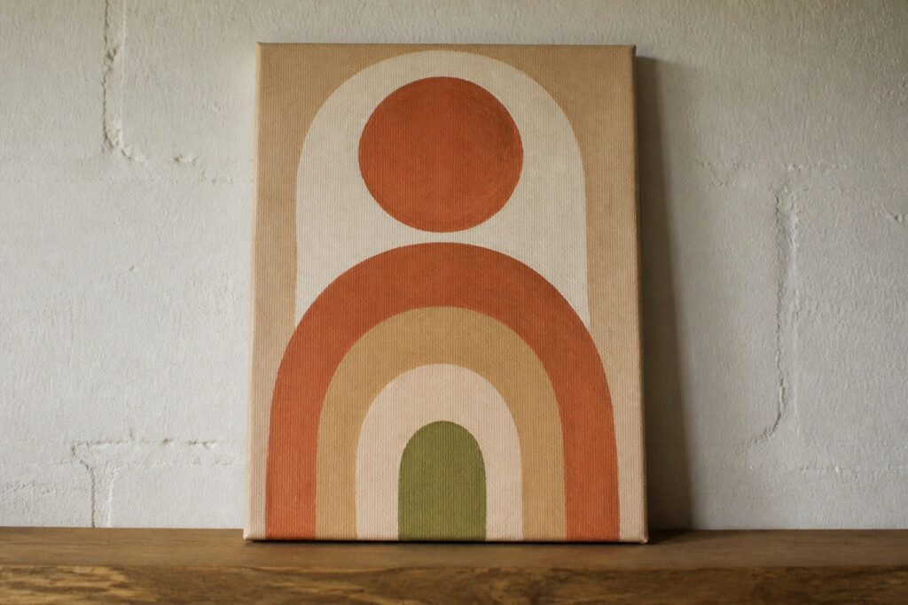 22 Chic Boho Canvas Painting Ideas for Warm Neutral Room Decor Boho canvas with terracotta sun rays above layered earth-tone rainbow arches.