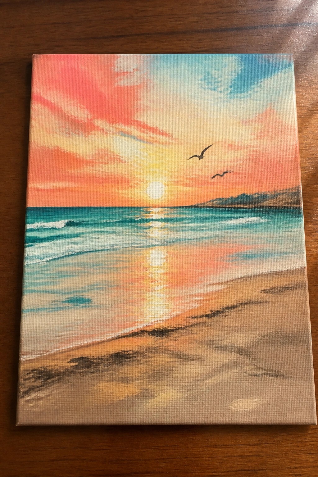 Vibrant sunset beach painting with colorful sky, ocean waves, sandy shore, and birds.