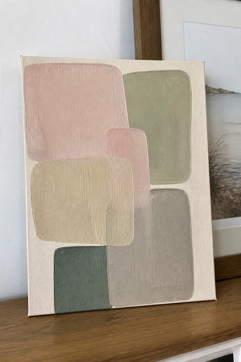 Abstract canvas with overlapping soft pastel shapes in pink, green, beige, and gray.