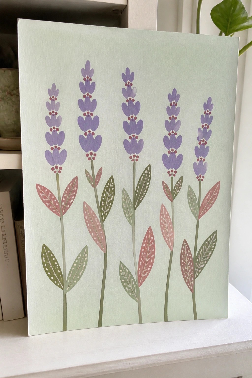 Five purple lavender stems with pink and green dotted leaves on light green canvas
