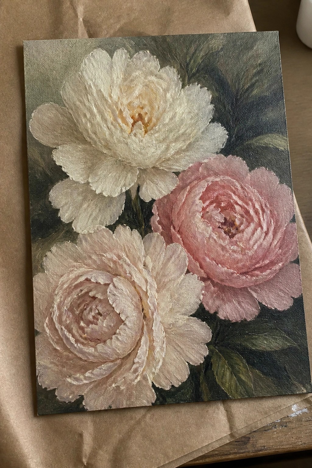 Oil painting of three peonies in soft white and pink with green leaves