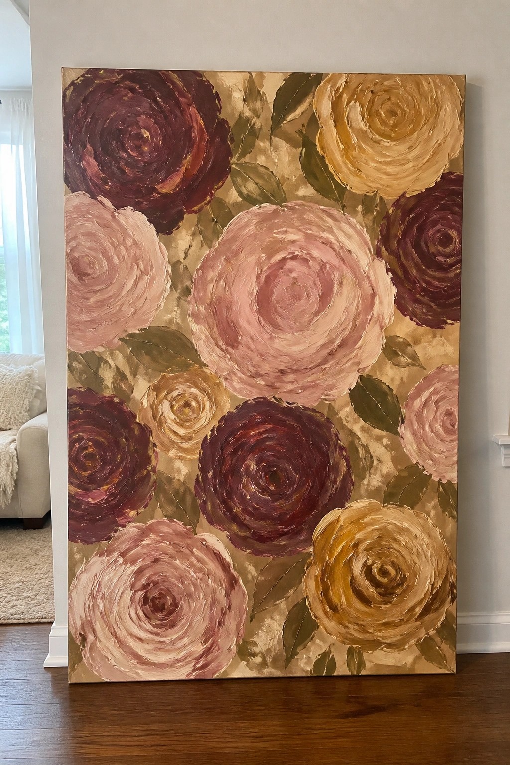 Large textured painting of pink, burgundy, and yellow roses with green leaves indoors