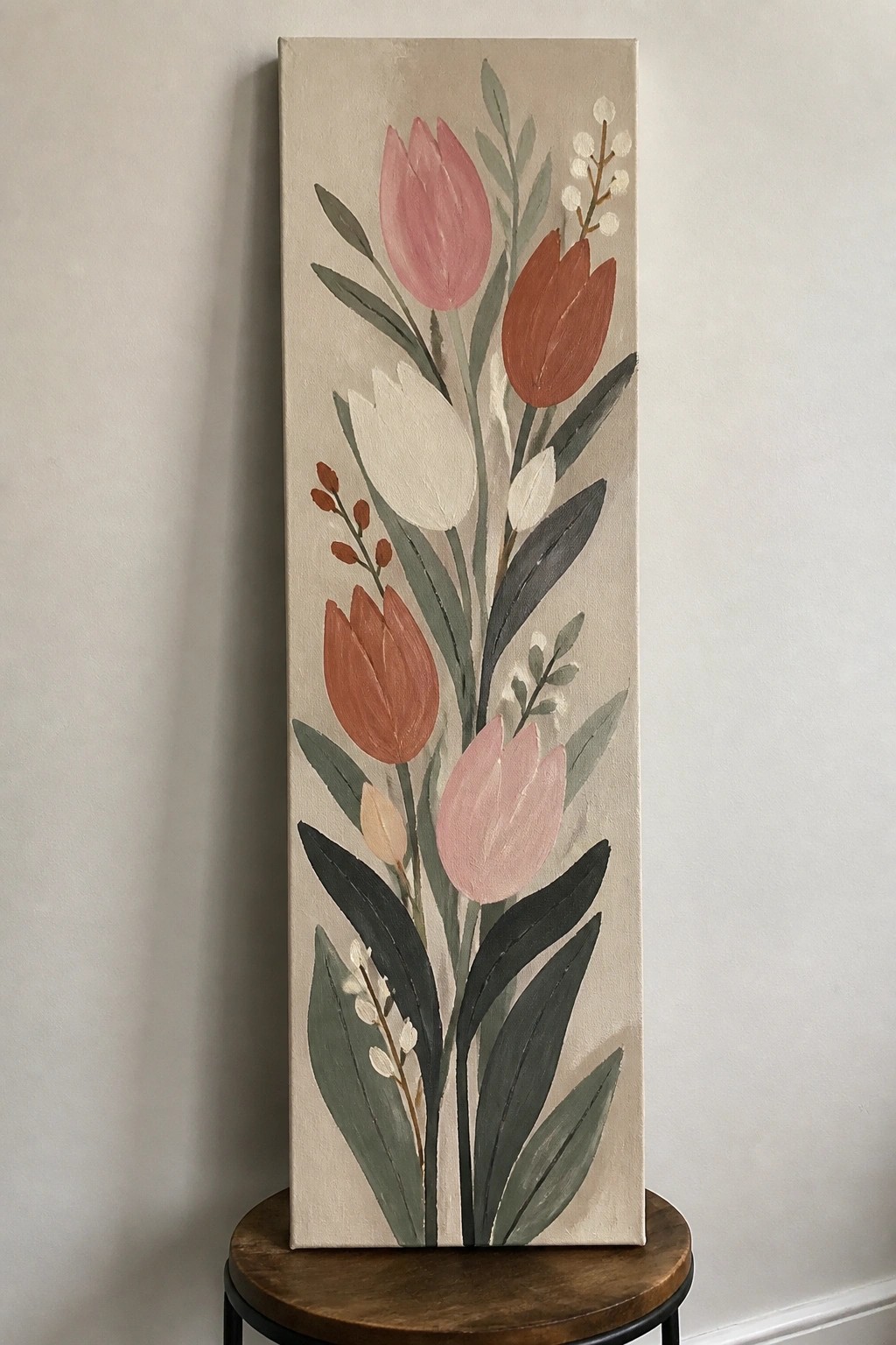 Tall beige canvas with pink and terracotta tulips plus green leaves on wooden stool