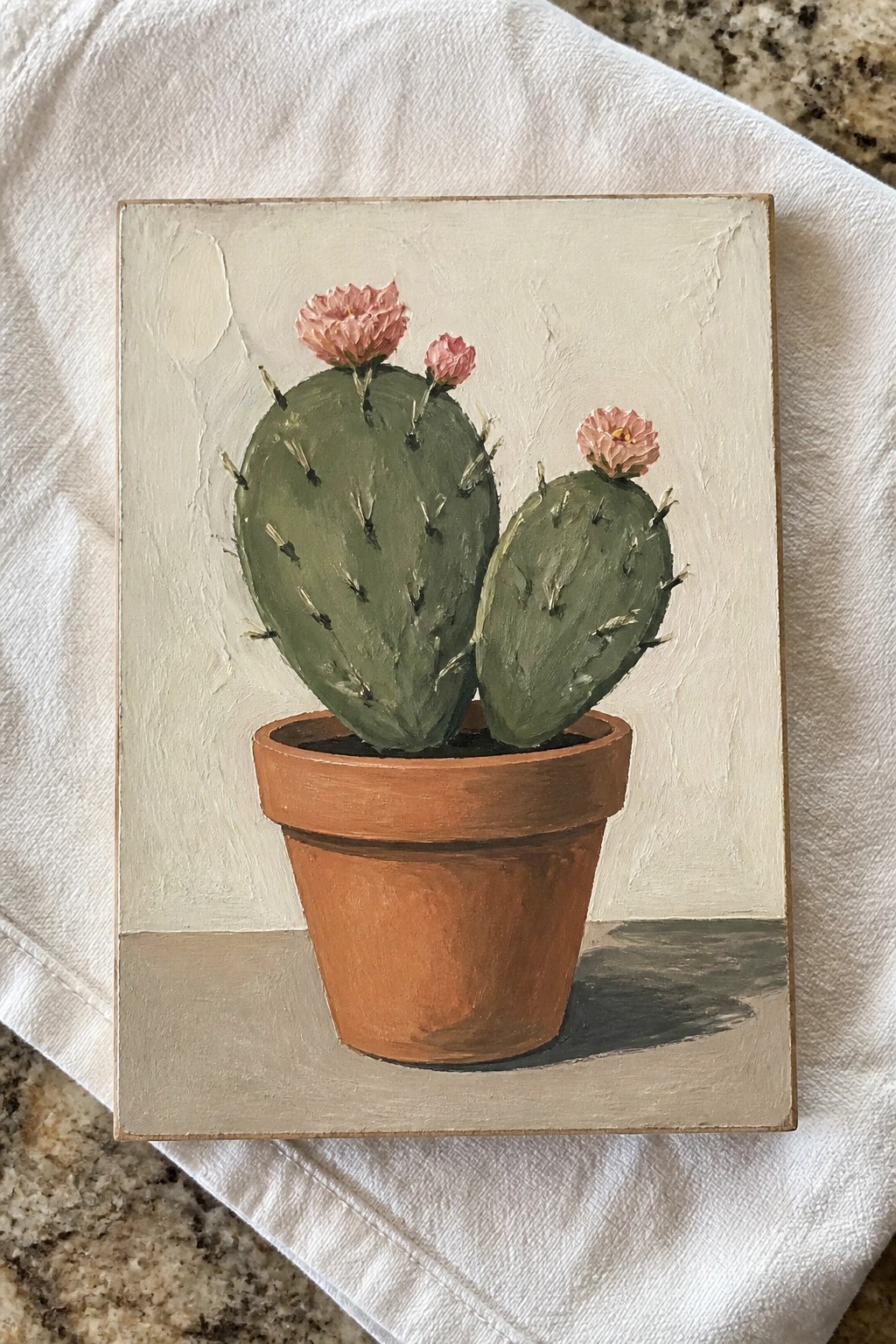 Still life painting of green cactus with pink flowers in terracotta pot