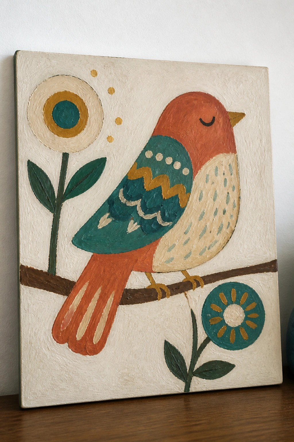 Folk-art painting of a red-headed teal bird perched on branch with flowers