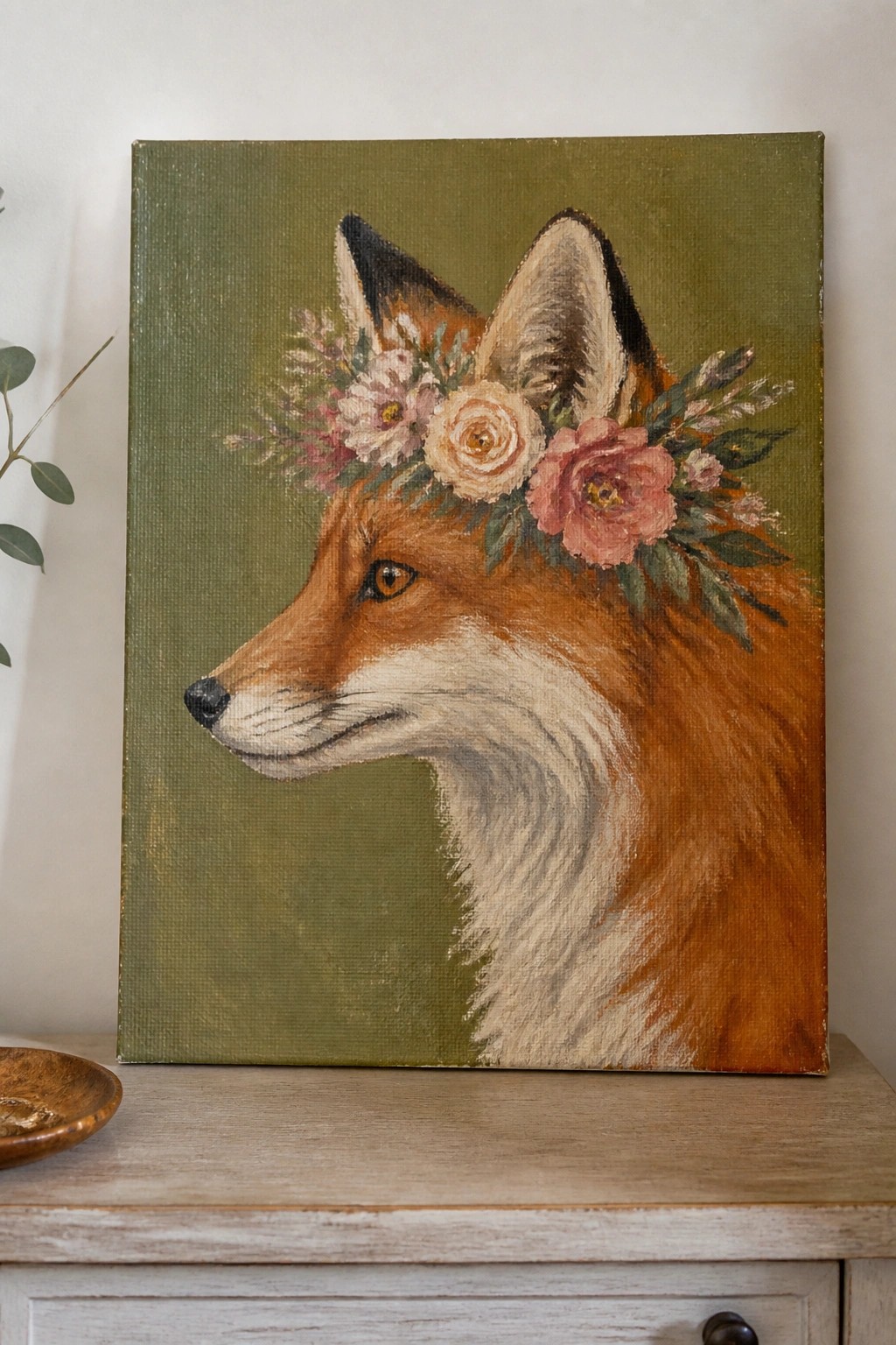 Red fox in profile wearing pink rose flower crown on green canvas.