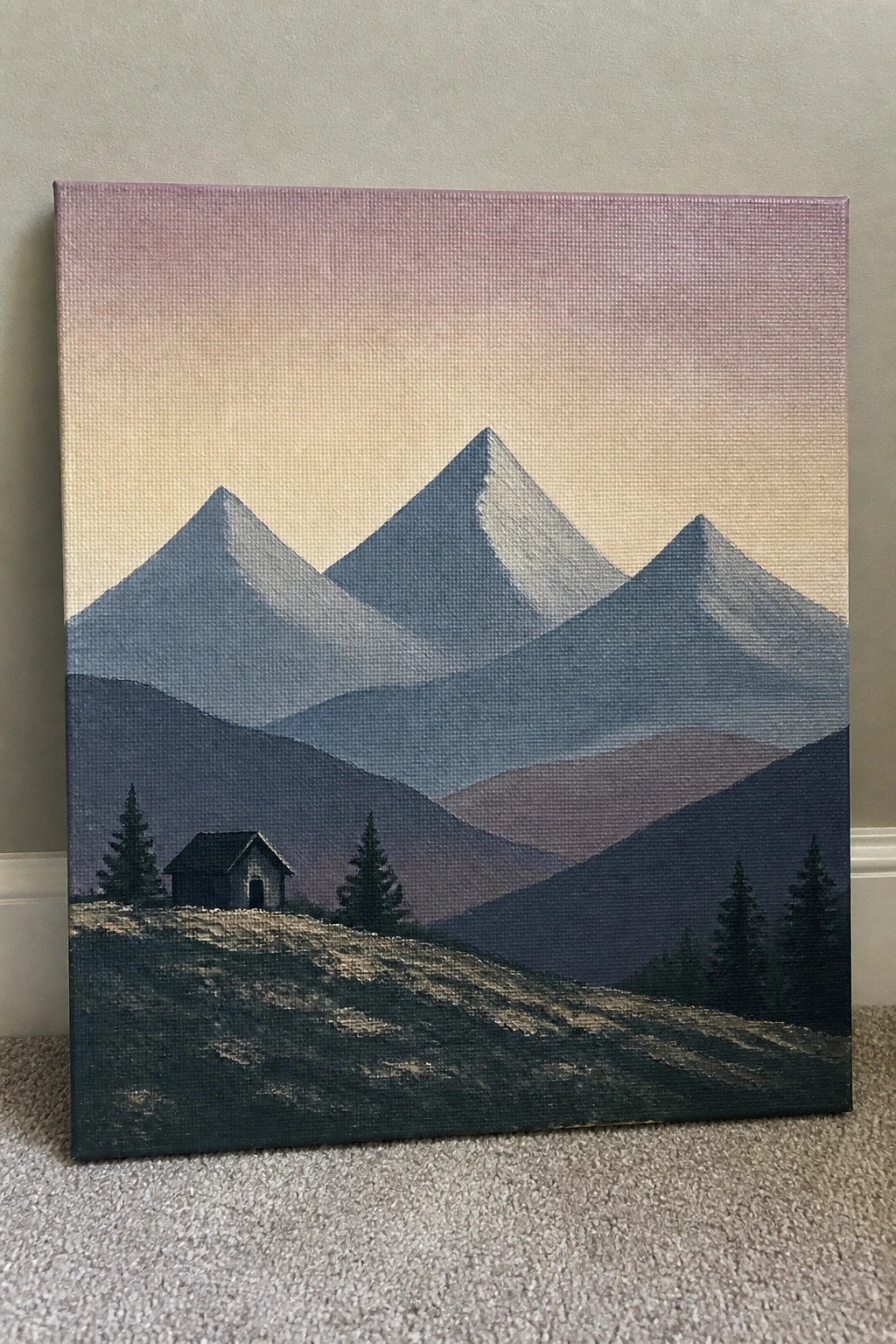 Layered blue mountains under pink-yellow sky with cabin and pine trees on hill.