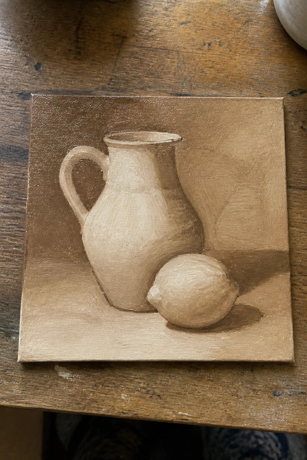 Brown-toned still life painting of pitcher and lemon on wooden table.