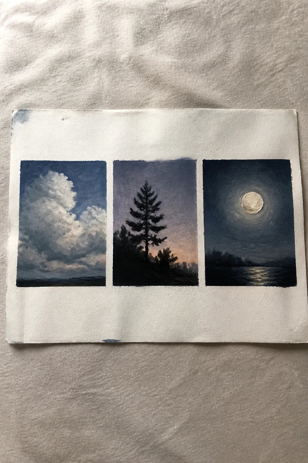 Three watercolor panels depict clouds, a pine silhouette at dusk, and a glowing moon over water.
