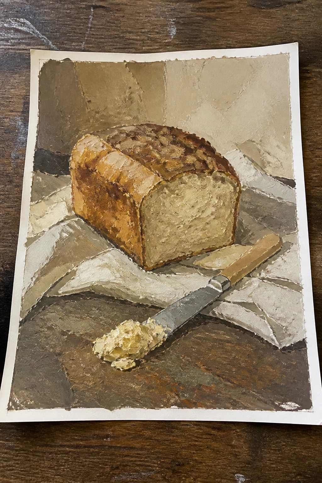 Thickly textured painting of sliced brown bread beside a buttered knife on cloth.