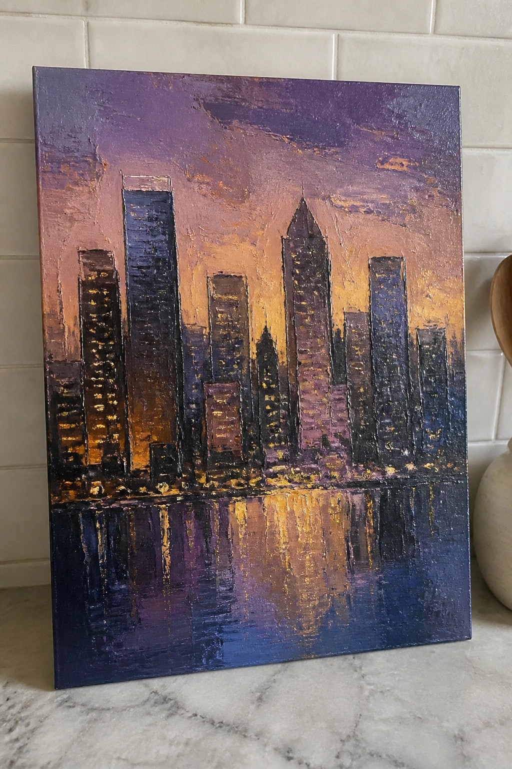 Abstract painting of skyscrapers at sunset with purple-orange sky and golden water reflections
