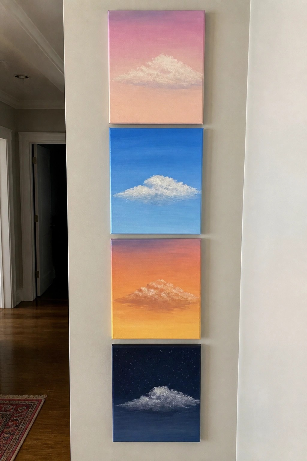 Four stacked paintings of clouds in pink, blue, orange, and starry night skies.