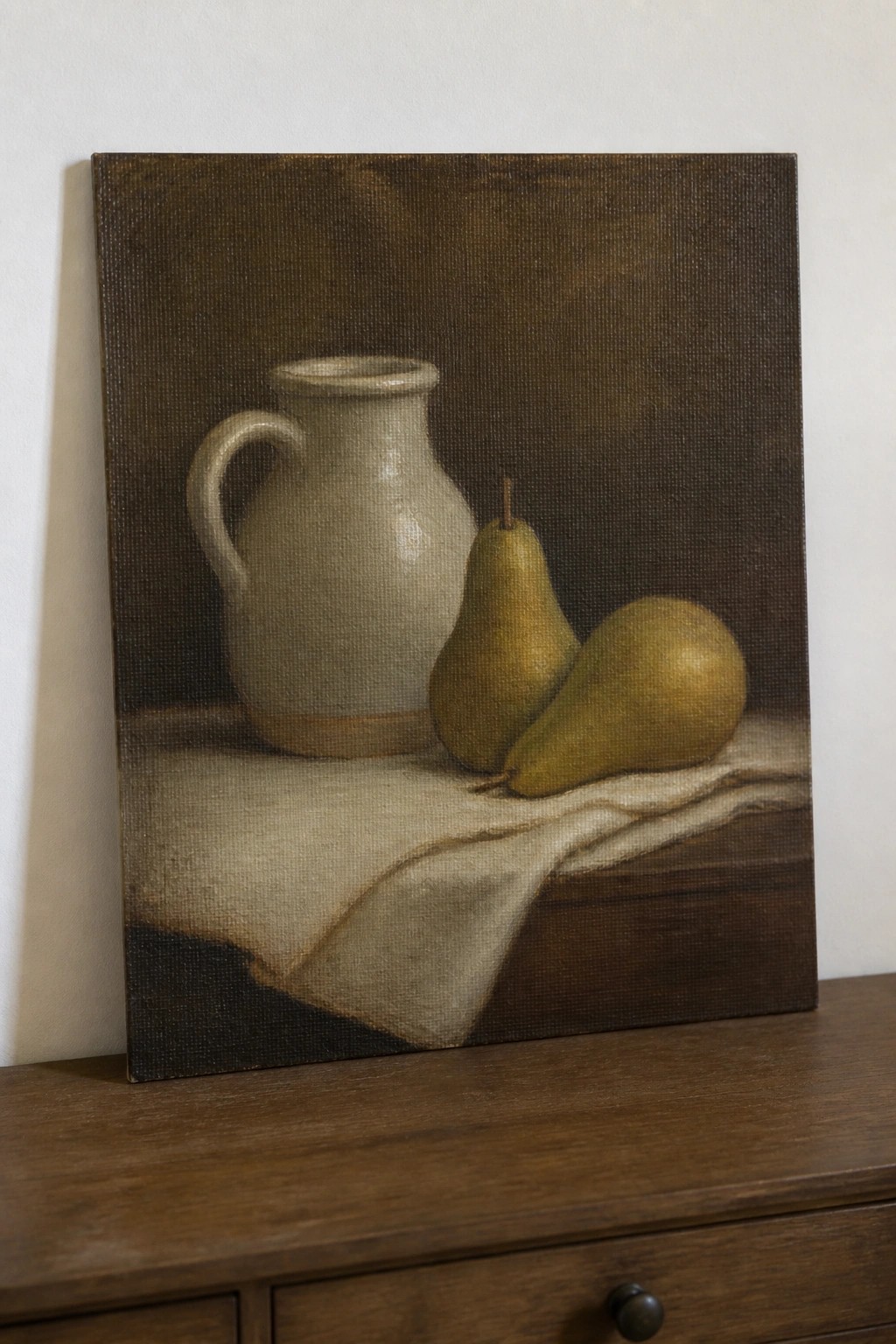 Still-life painting of white pitcher and two pears on draped cloth over wood