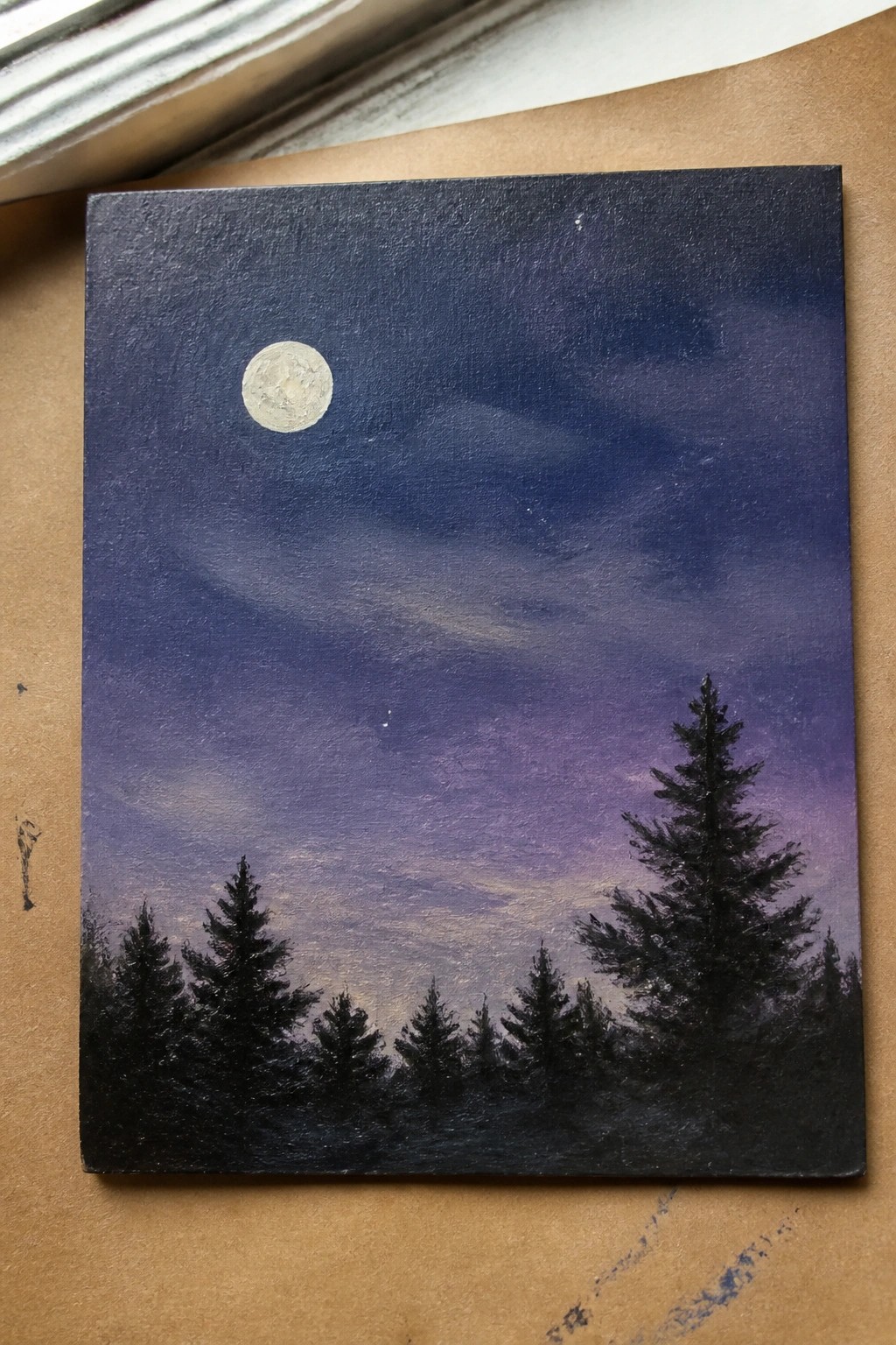 Moonlit night sky painting with purple clouds and silhouetted pine trees.