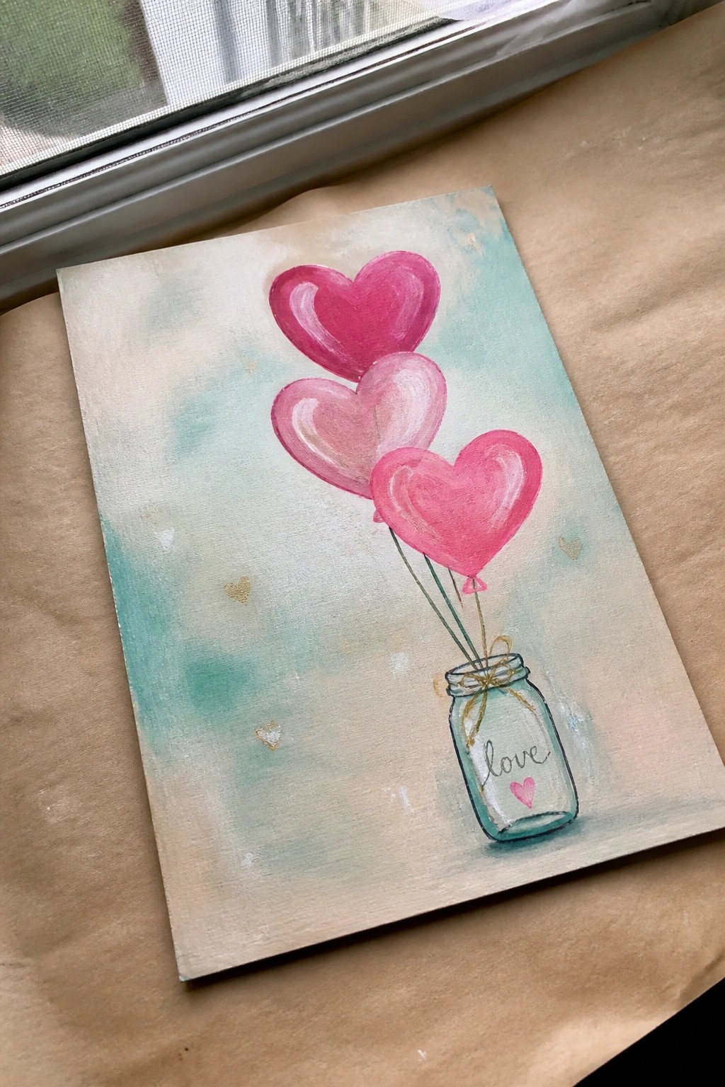 Watercolor painting of three pink heart balloons tied to a mason jar labeled love.
