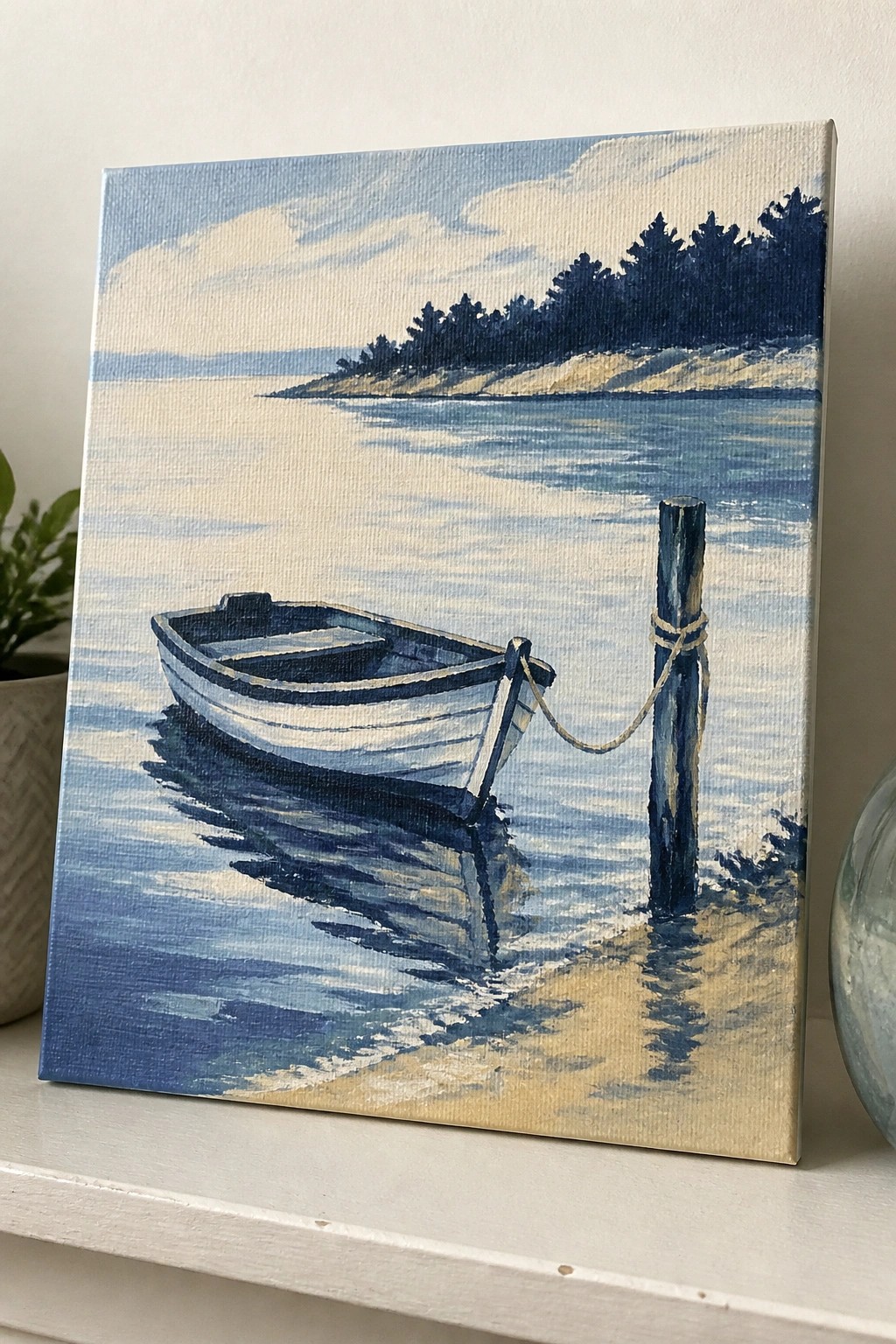 Blue and white rowboat tied to post on sandy shore with calm blue water.