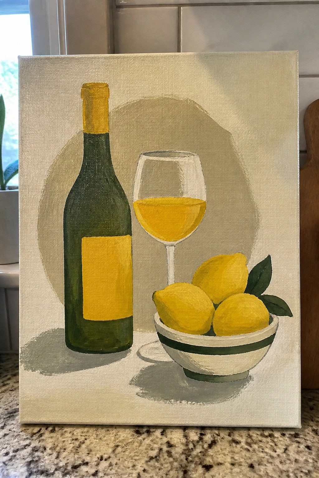 Painting of green wine bottle, yellow wine glass, and bowl of lemons on canvas.