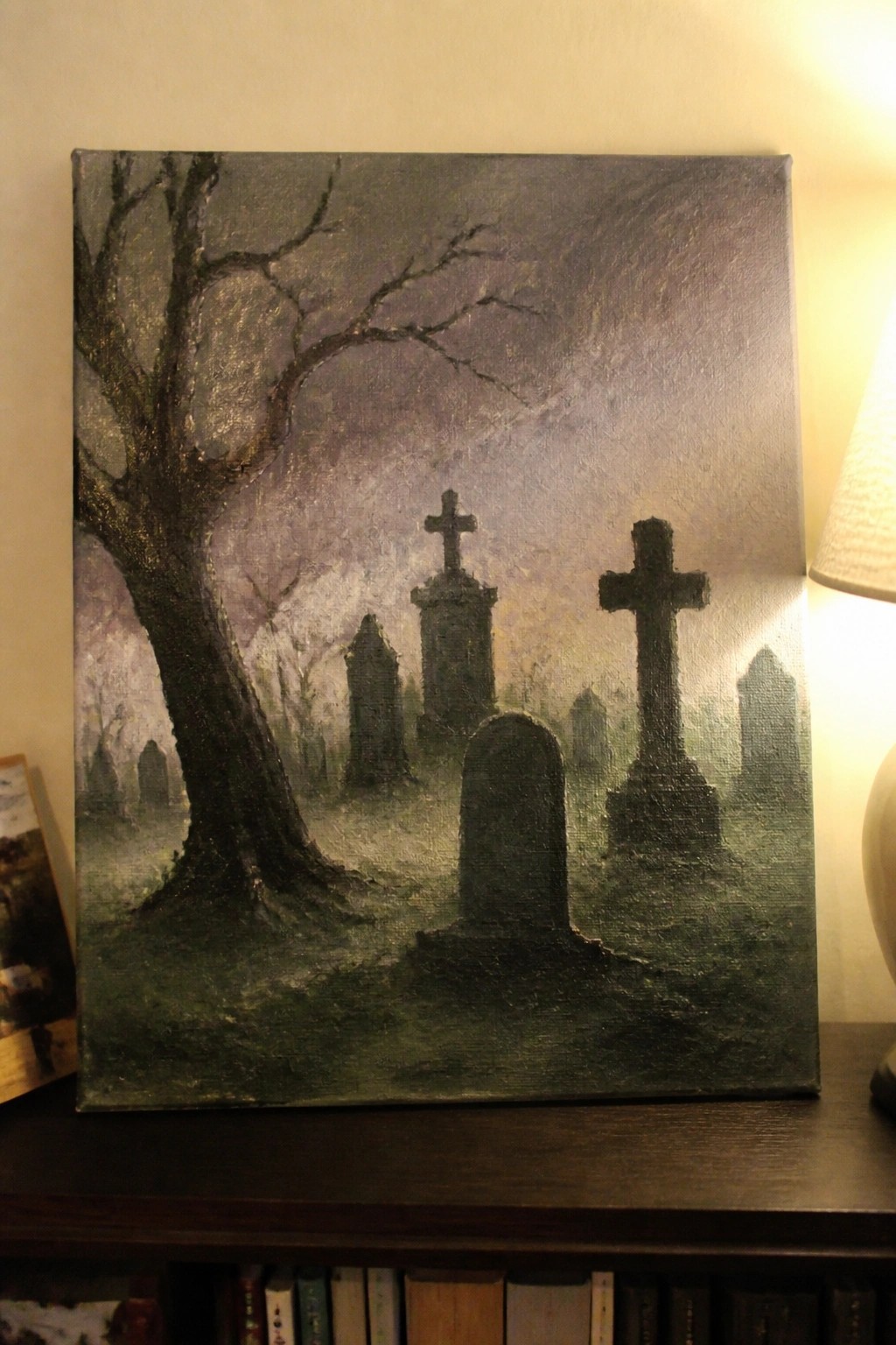 A canvas painting shows a foggy graveyard at dusk with a large bare tree on the left and several dark gravestones including crosses.