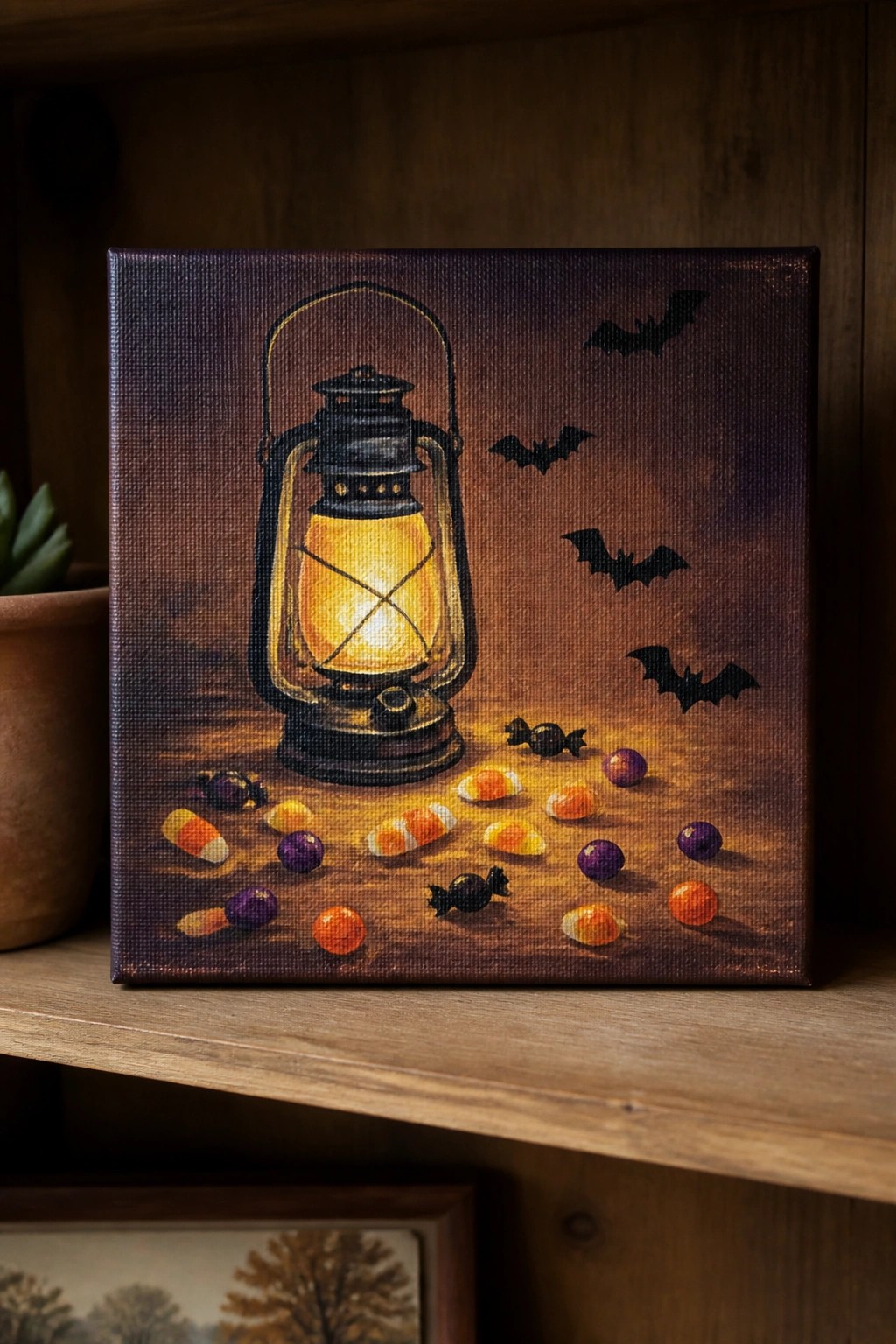 Glowing lantern with candy corn, wrapped sweets, and black bats on canvas