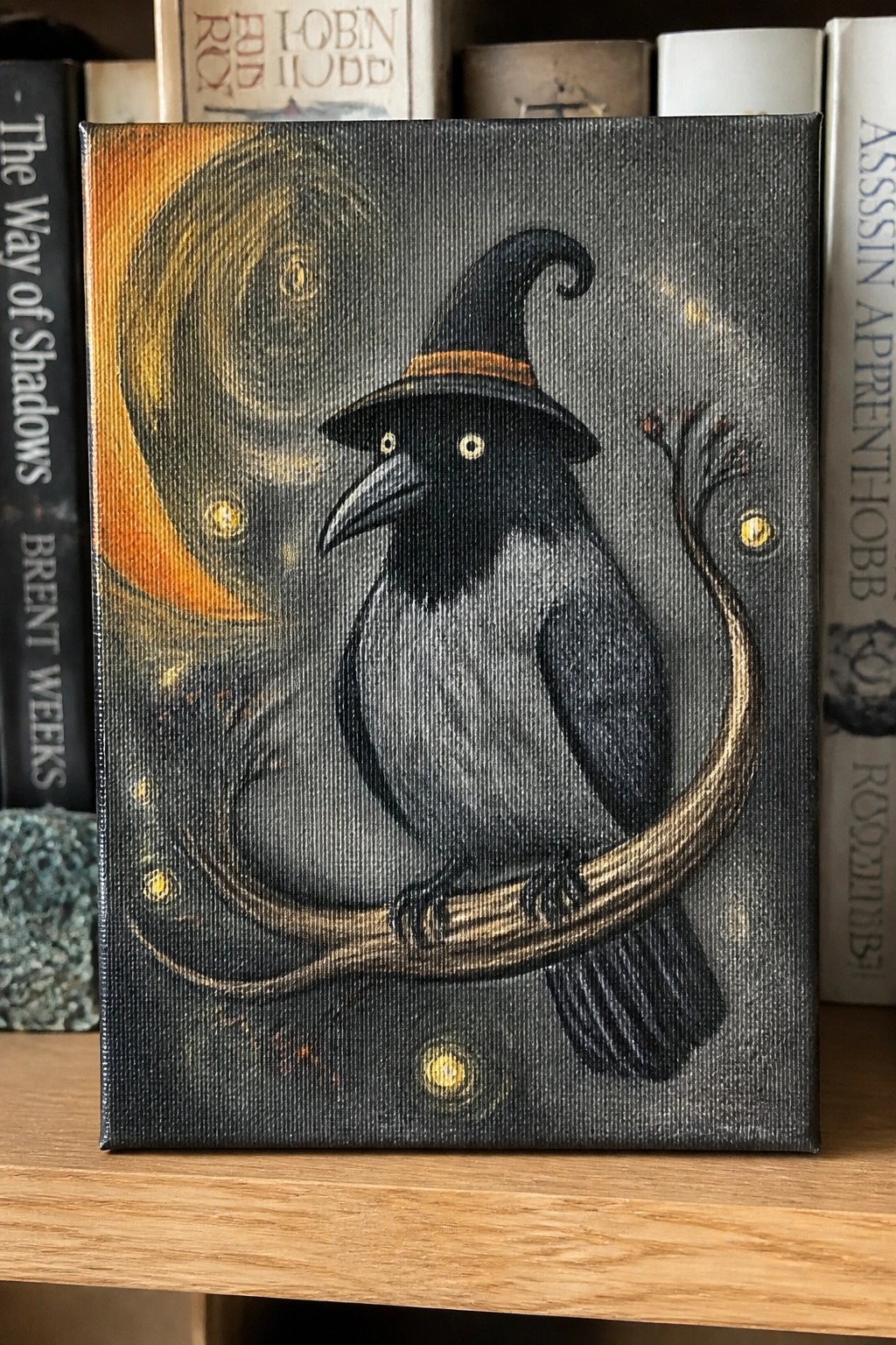 Black raven in witch hat perches on branch amid swirling moon and glowing orbs