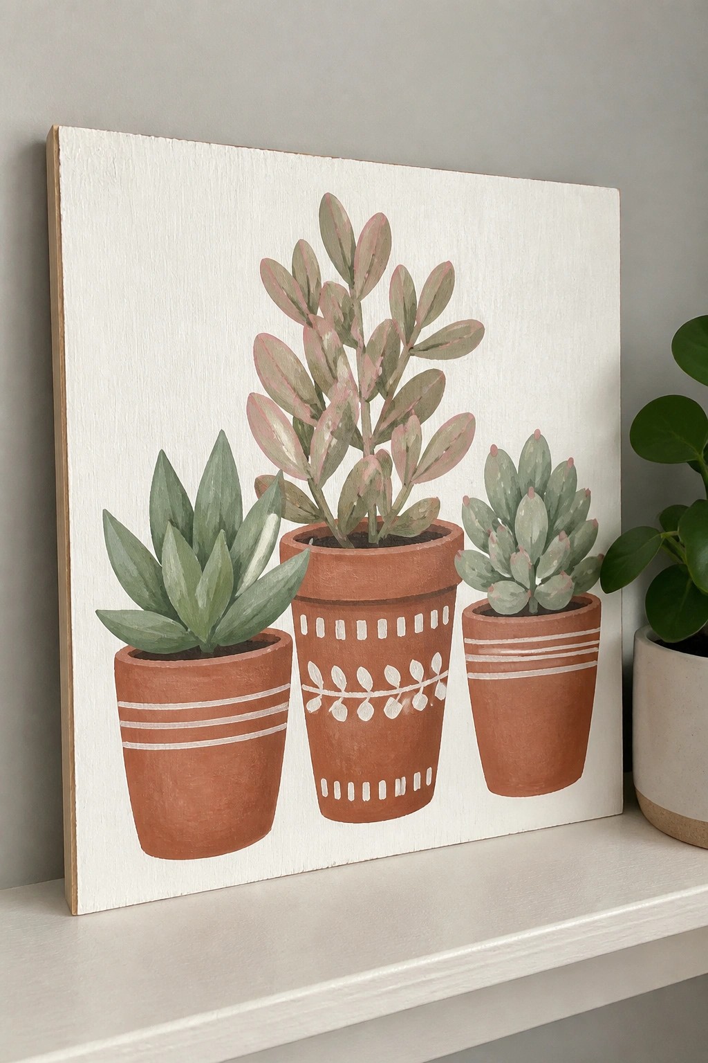 Three succulents in patterned terracotta pots painted on white canvas.