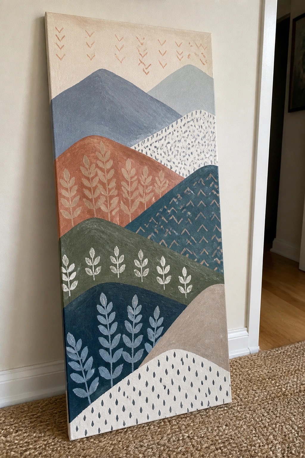 Colorful abstract landscape painting with layered hills and leaf patterns on canvas.