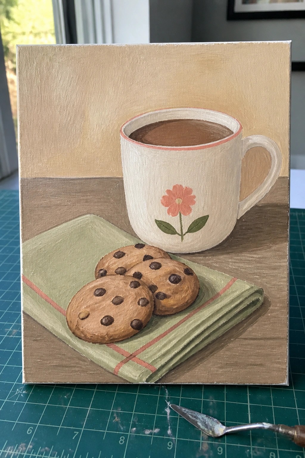 Still life painting of floral coffee mug beside cookies on green napkin