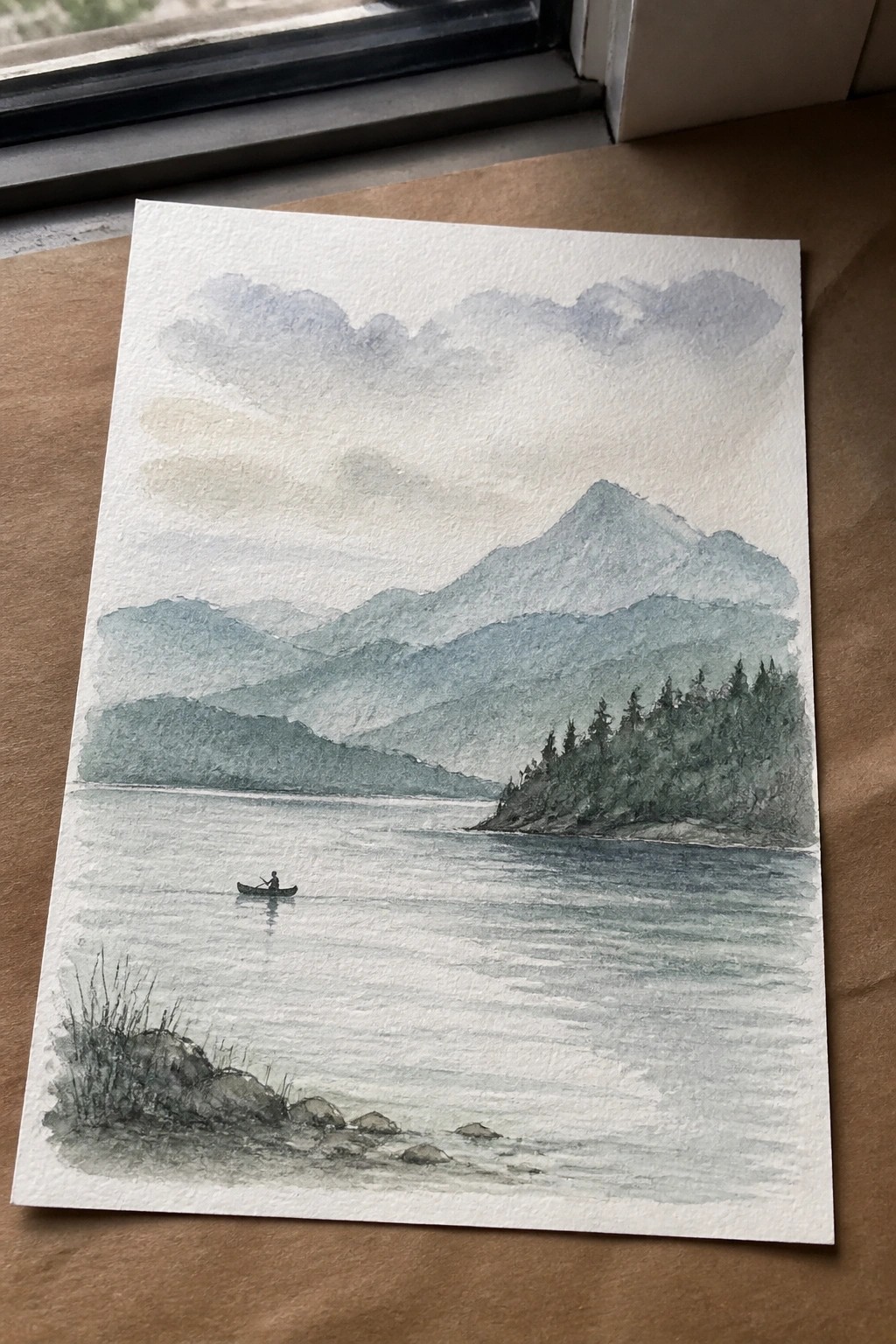Watercolor landscape of misty mountains, calm lake with canoe, and rocky shore
