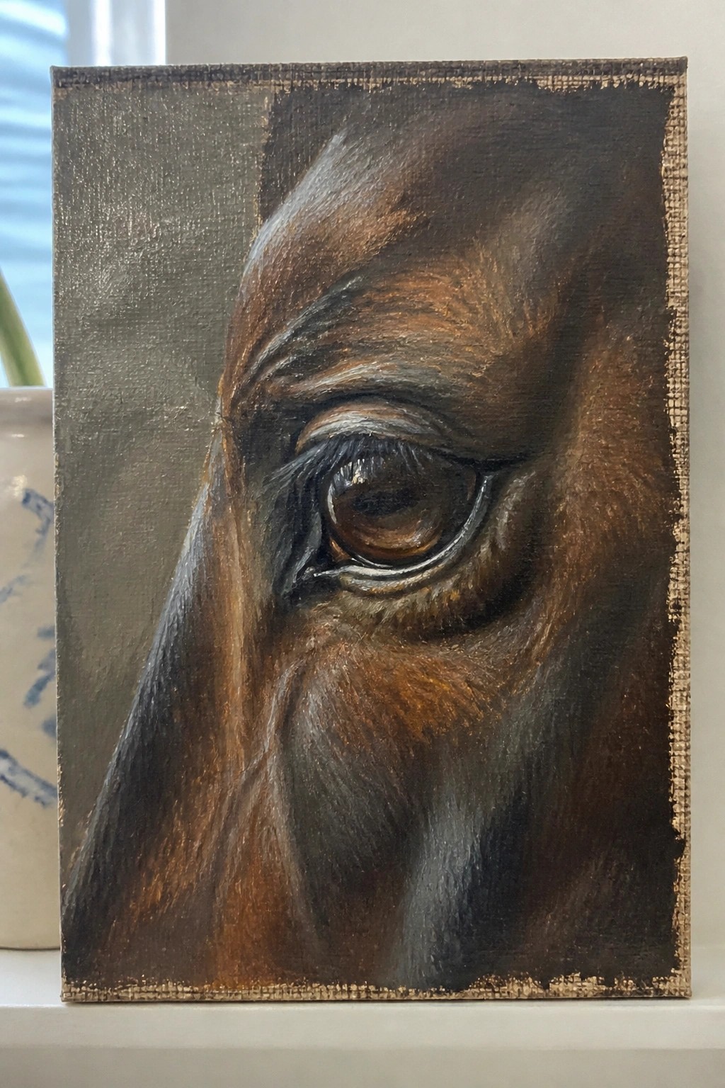 Realistic close-up painting of a dark brown horse's eye on canvas