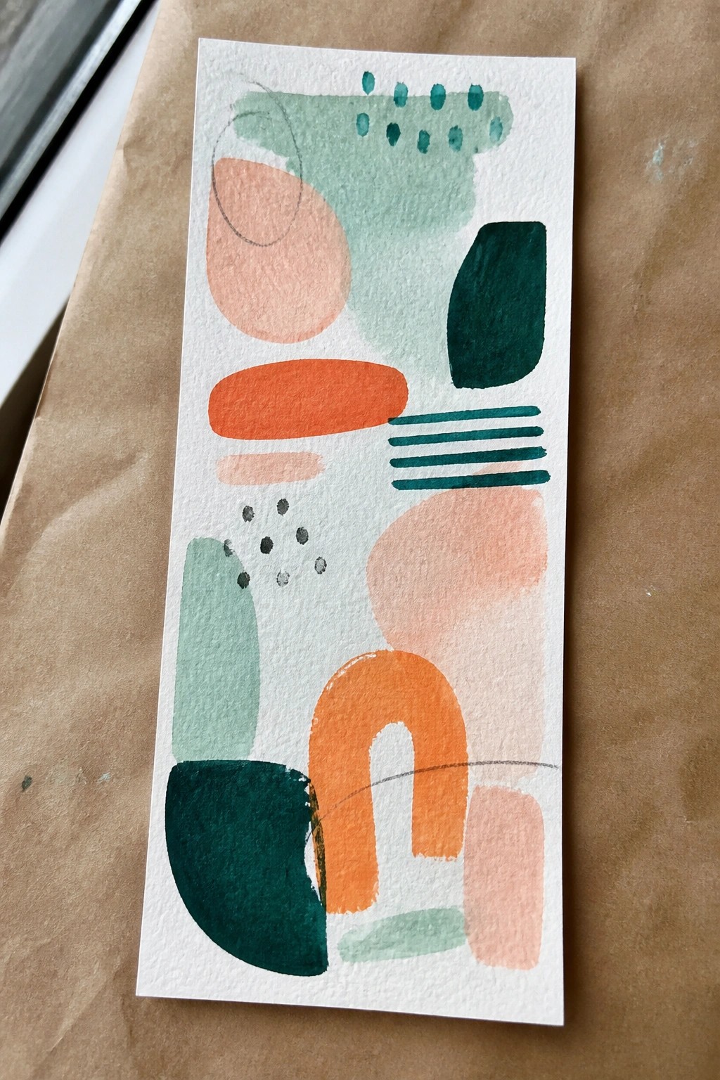 Abstract artwork with peach, orange, teal, and green shapes on white paper