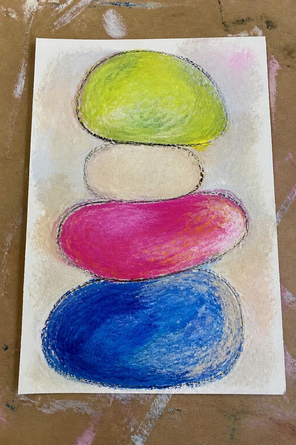 Stacked pastel ovals in lime green, beige, magenta, and blue resembling balanced stones