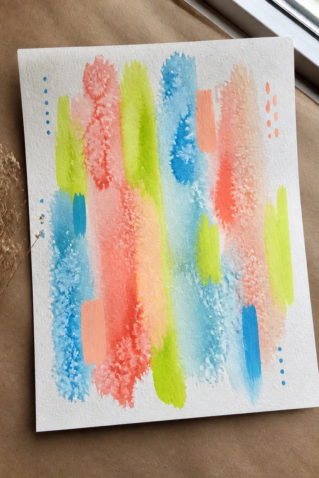 Abstract watercolor painting with vibrant overlapping brushstrokes in red, pink, blue, green, and orange.