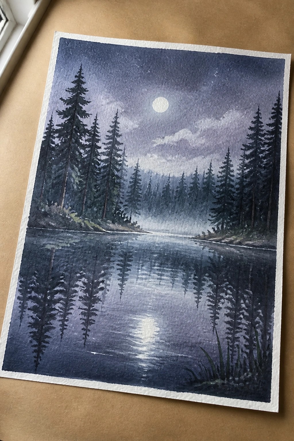 Watercolor night landscape of misty lake with pine trees and full moon reflections.