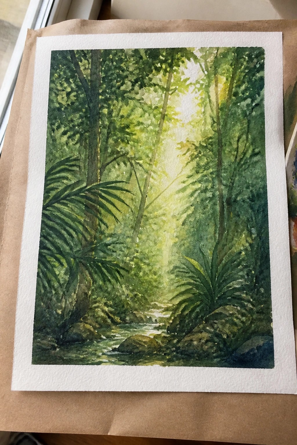 A watercolor painting of a lush green forest with sunlight rays piercing through tall trees and a small stream flowing over rocks in the foreground.