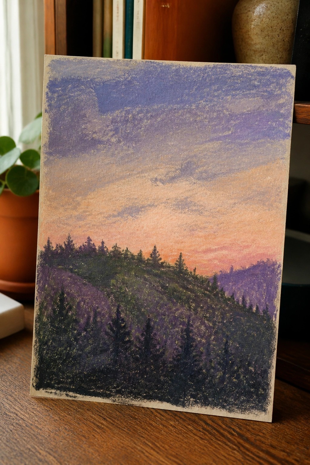 Colorful pastel landscape of dark forest hills under purple-orange sunset sky