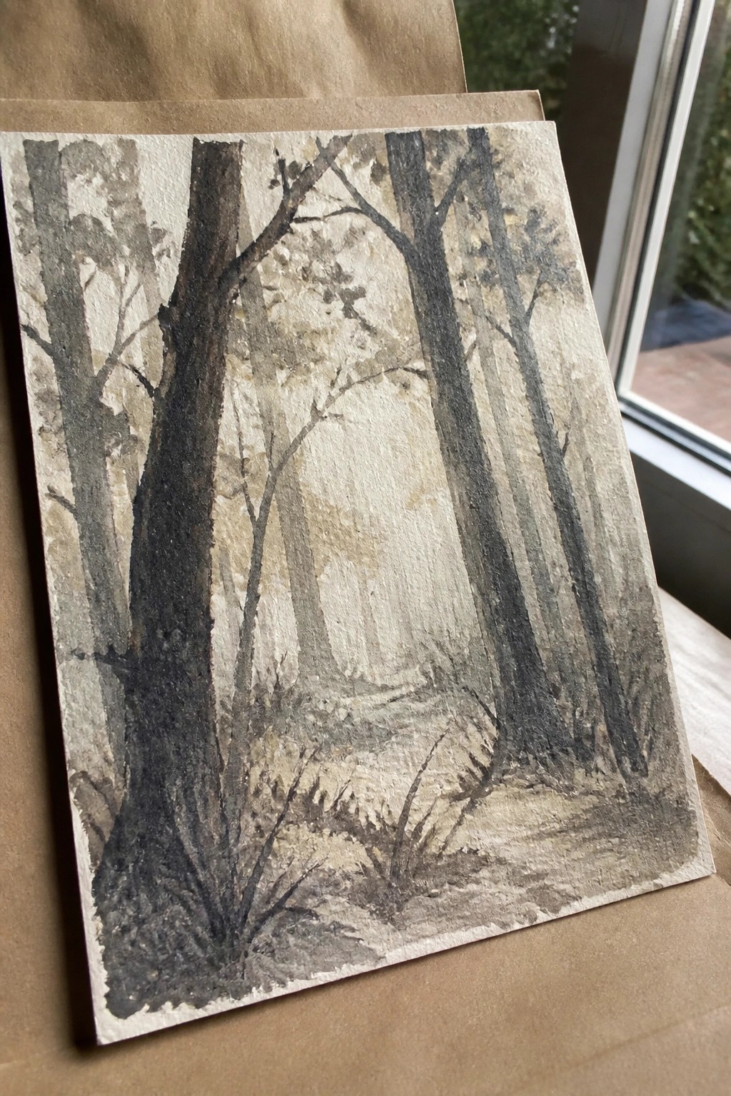 Watercolor painting of tall dark trees along a misty forest path in earthy tones