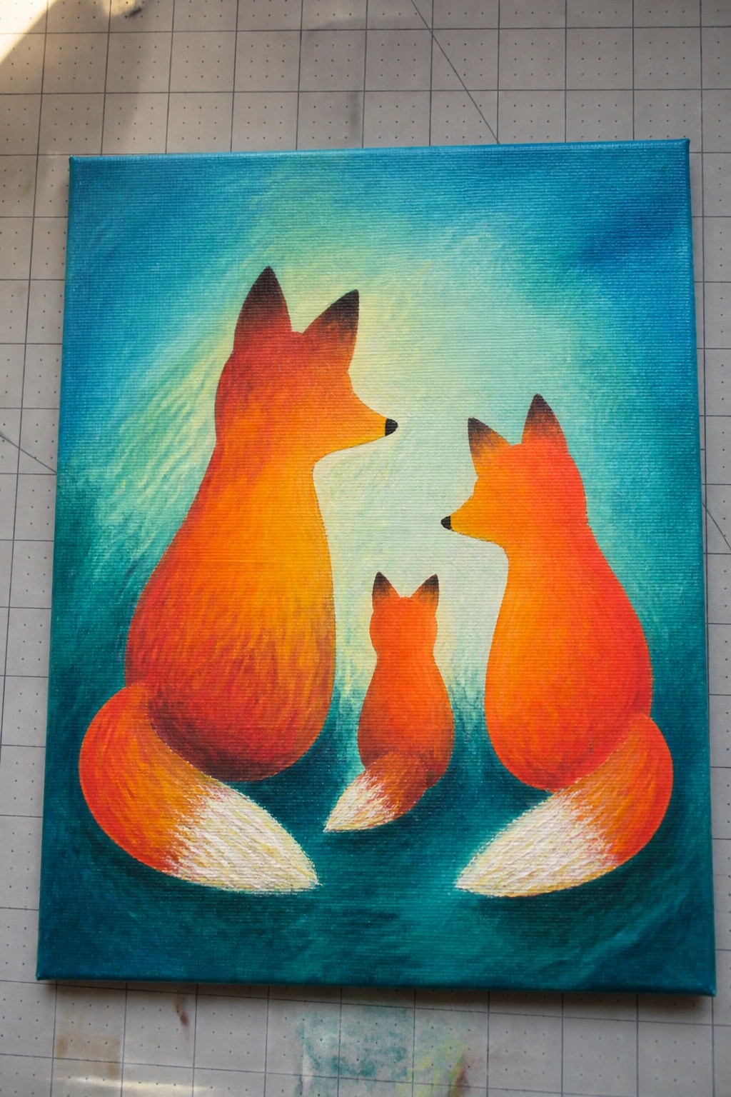 Three stylized orange foxes with white tails on a swirling teal background.