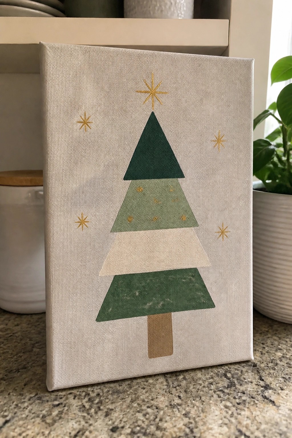 Minimalist canvas with layered green triangle Christmas tree, gold stars, and brown trunk.