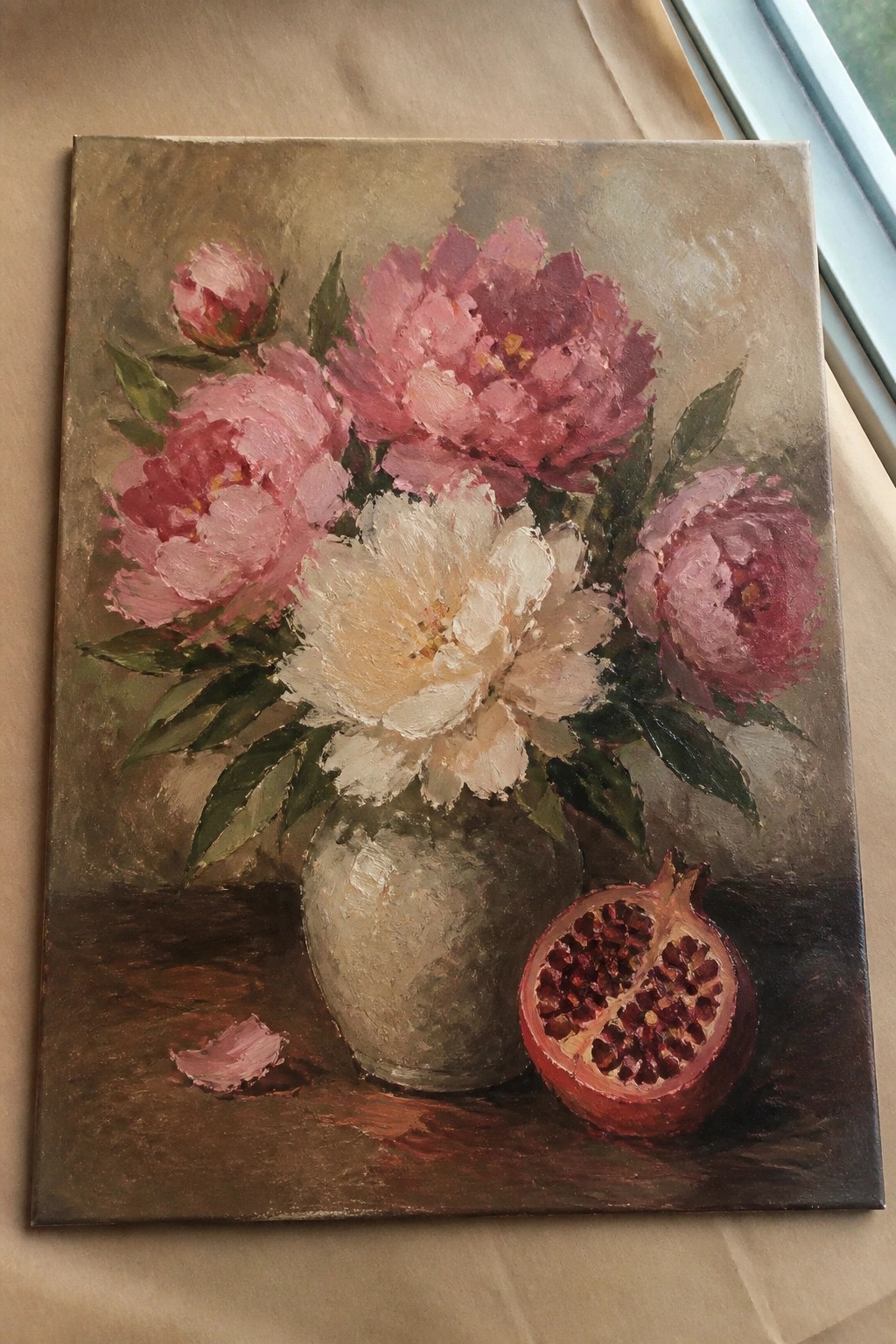 Oil painting of pink and white peonies in a vase with cut pomegranate.