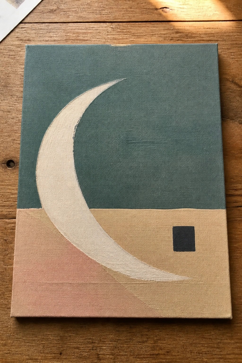 Abstract painting of white crescent on teal-beige background with small black square.