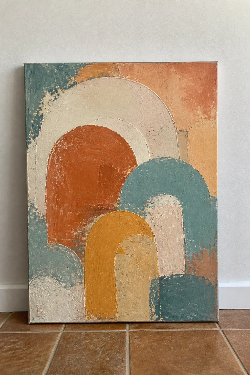 Abstract painting with overlapping arches in orange, teal, yellow, and beige on canvas.