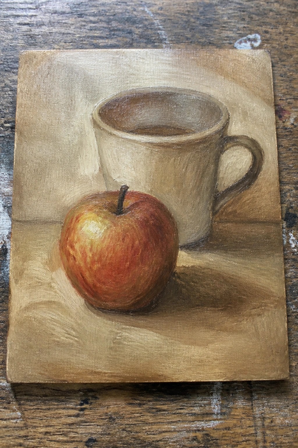 A realistic oil painting of a red apple beside a beige ceramic mug on a wooden surface.