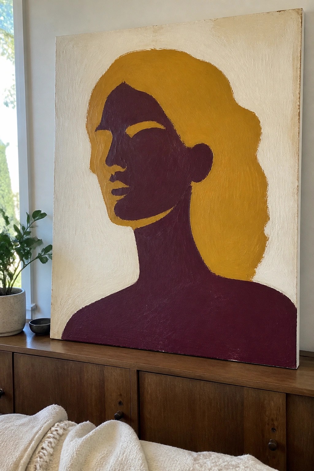 Abstract painting of woman's purple profile with yellow hair on wooden cabinet